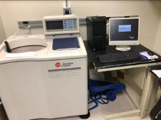 Beckman Coulter analytical ultracentrifuge connected to a desktop computer on a pull-out shelf in a laboratory workspace