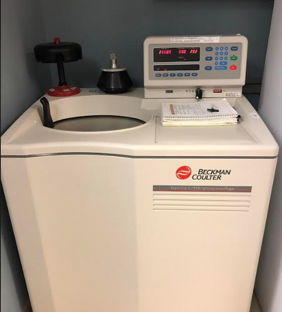 Beckman Coulter analytical ultracentrifuge connected to a desktop computer on a pull-out shelf in a laboratory workspace
