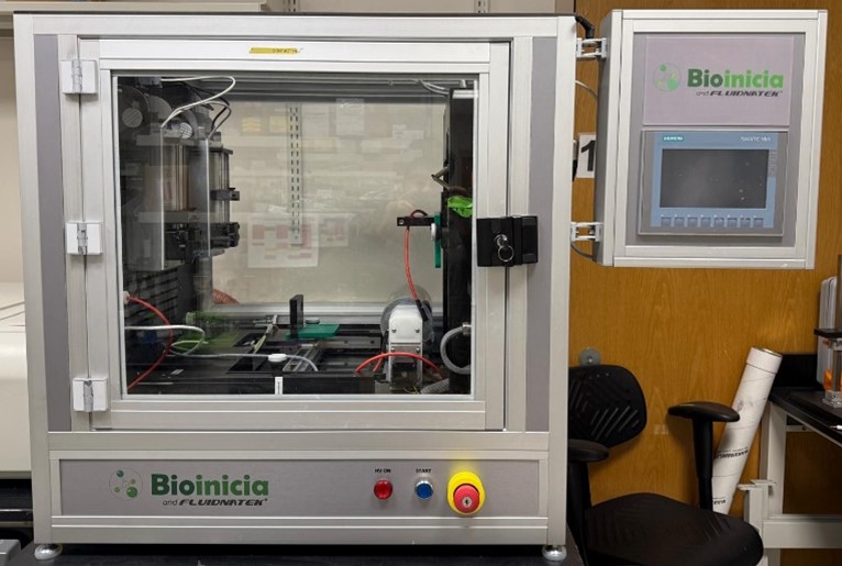 Bioinicia Fluidnatek electrospinning and electrospraying system enclosed in a clear safety cabinet with control screen and wiring visible inside
