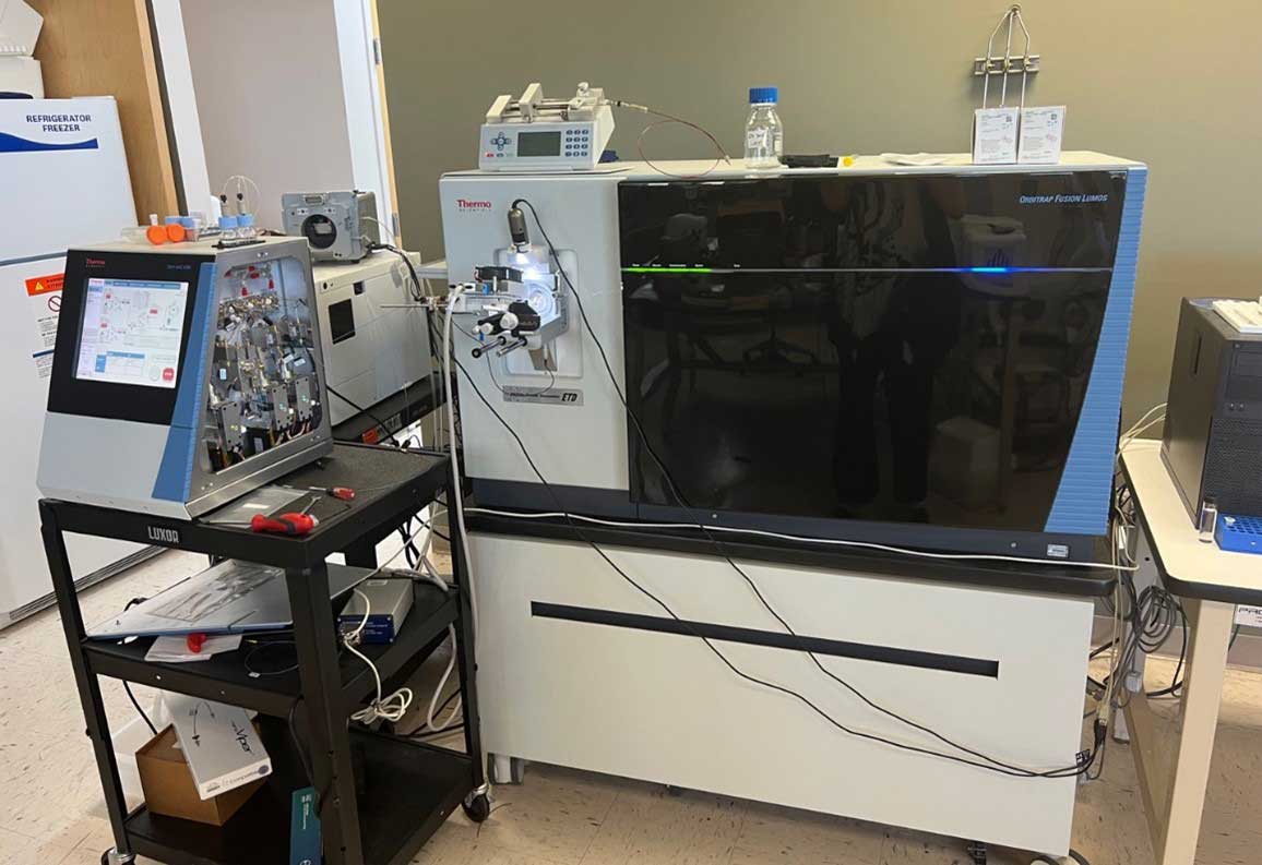 Thermo Scientific Orbitrap Fusion Lumos mass spectrometer setup in a lab, with adjacent control units, tubing, and connected instruments