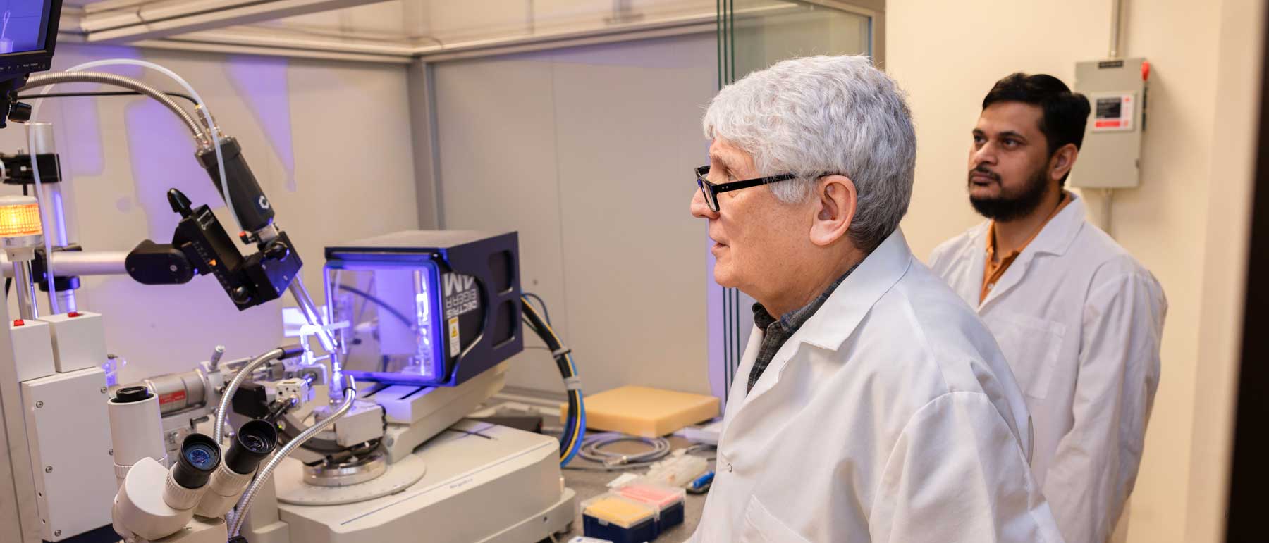 A graduate student and a professor work together on an X-ray diffractometer in a medicinal chemistry lab